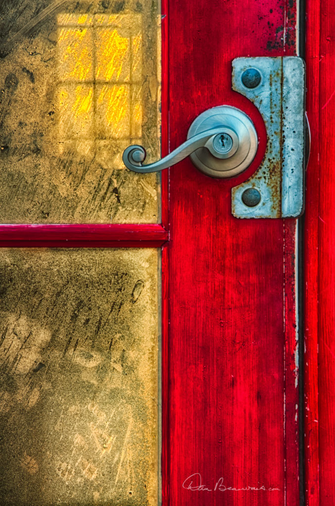 The red door on the front of Kitty Hawk Pier.  The golden light of dawn streams through the pier building, highlighting the condensation on the inside of the door glass.